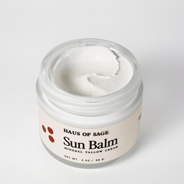 Top view open jar of 'Haus Of Sage Sun Balm' on a white background.