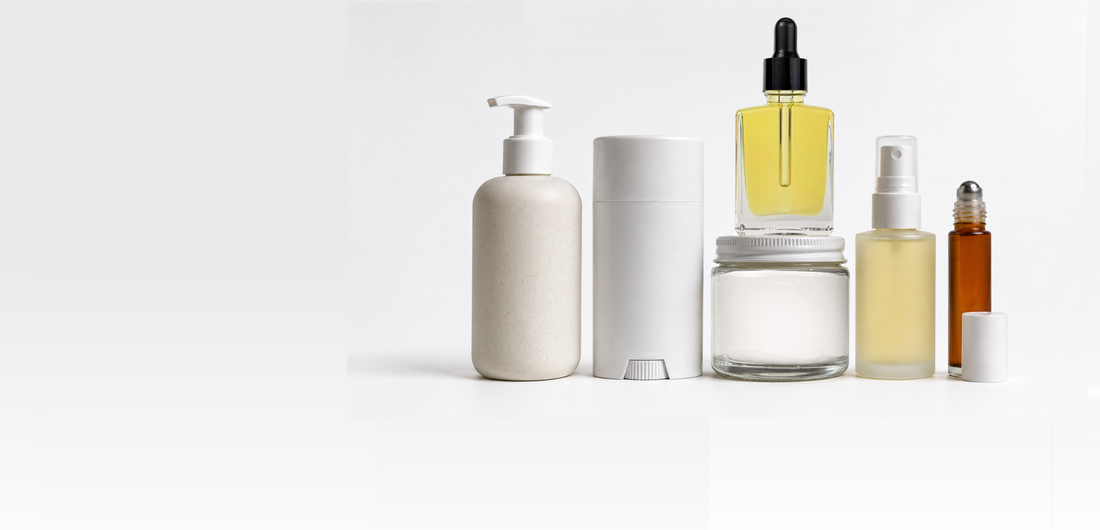 A set of minimalist, unbranded cosmetic and skincare containers on a seamless white background, including a pump bottle, a cylindrical tube, a dropper bottle, a jar, a spray bottle, and a rollerball bottle.