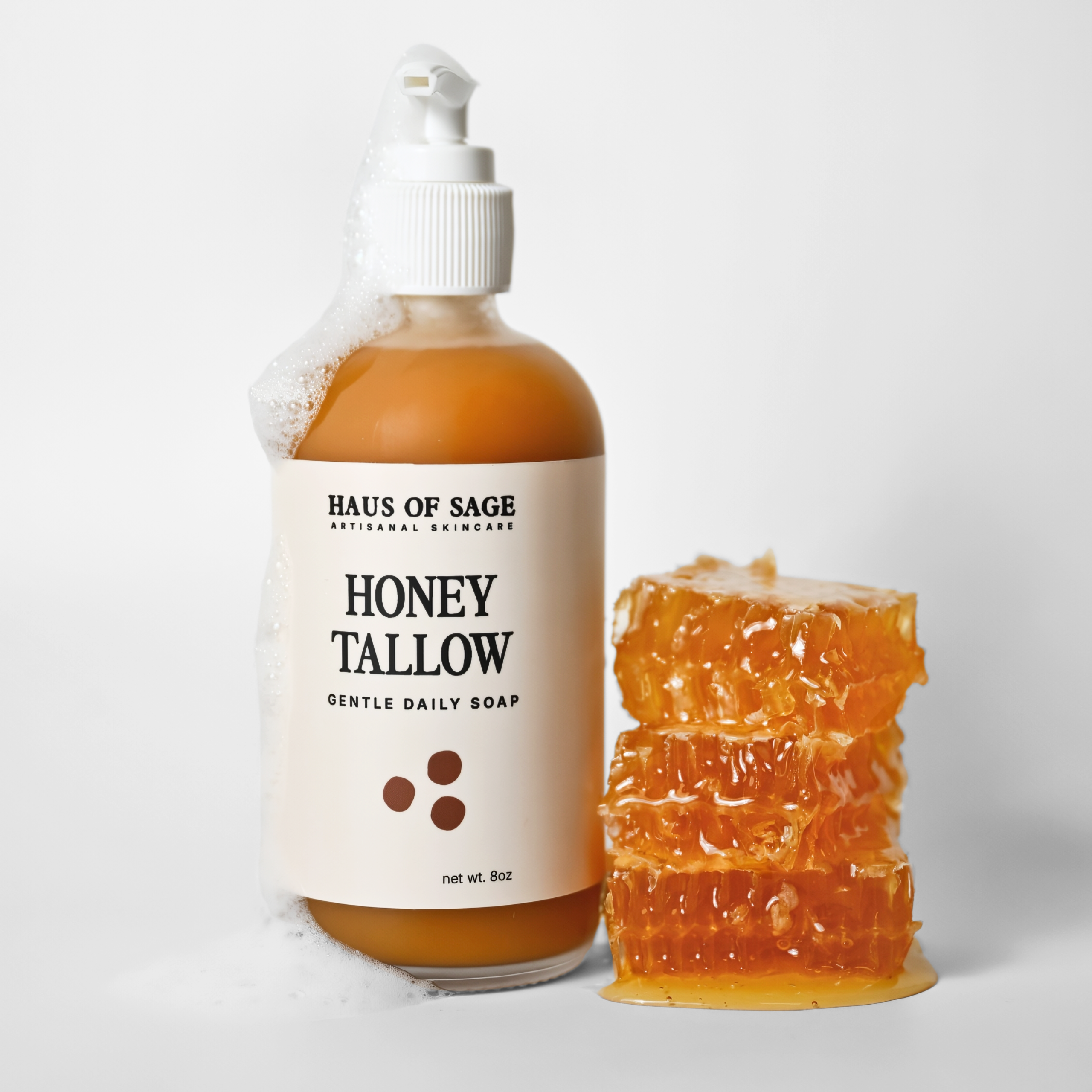Bottle of Haus of Sage Honey Tallow soap with a honeycomb on a white background