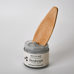 Jar of Haus of Sage deodorant with a wooden applicator on a light gray background